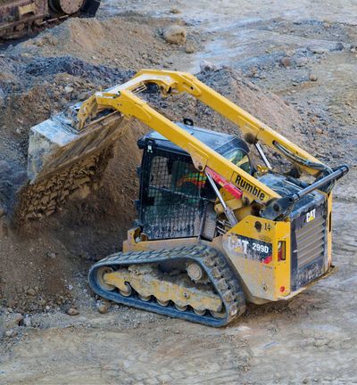 Front-end loader clear dirt to prepare foundation for a construction project
